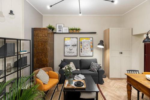 sala de estar con sofá gris y sillas naranjas en Nobel Apartment - BEST LOCATION!, en Cracovia