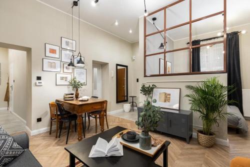 Una sala de estar con una mesa y un comedor. en Nobel Apartment - BEST LOCATION!, en Cracovia