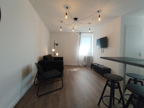 a living room with a table and chairs at Résidence Beaudelot in Saint-Saulve
