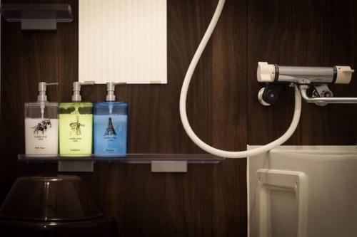 a bathroom with a shelf with toiletries on it at Snow House Hotel in Sapporo