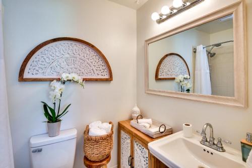 a bathroom with a sink and a toilet and a mirror at Bright Florida Home with Patio and Grill, Near Beaches in New Smyrna Beach