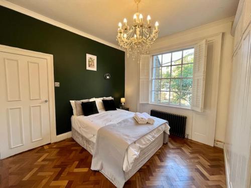 a bedroom with a large bed and a chandelier at Islington - Greater London Apartment in London