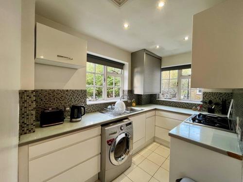 a kitchen with a washer and a washing machine at Islington - Greater London Apartment in London