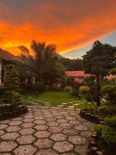 a sunset over a stone walkway in a yard at Bungalow Sáng Tươi Mountains in Phu Quoc