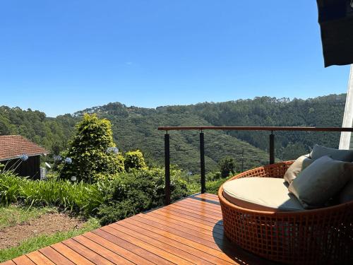 a wooden deck with a chair on top of a mountain at Pousada das Pedras in Monte Verde
