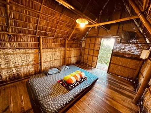 una camera con un letto in una capanna di paglia di Phú Sĩ Homestay và Seafood Núi Cấm 