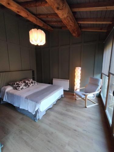 ein Schlafzimmer mit einem Bett und einem Stuhl darin in der Unterkunft Turisme Rural Ca l'Axai casa 3 in Pi