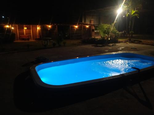 a swimming pool in the yard at night at La Villa Chalés Garden in Serra Negra