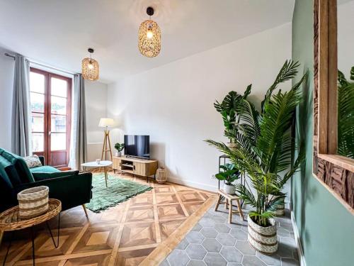 un salon avec un canapé et une plante dans l'établissement Hyper-centre de Grenoble, ambiance tropicale, wifi fibre, à Grenoble
