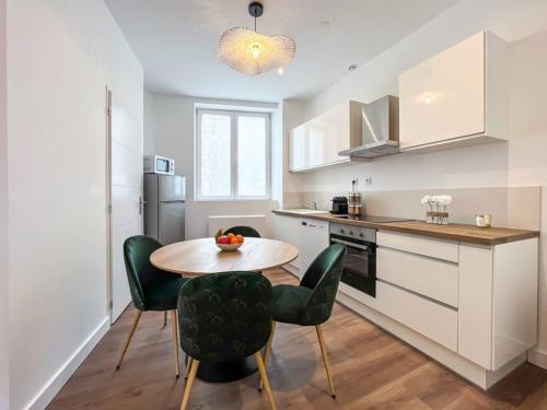 une cuisine avec une table et des chaises dans une cuisine dans l'établissement Hyper-centre de Grenoble, ambiance tropicale, wifi fibre, à Grenoble