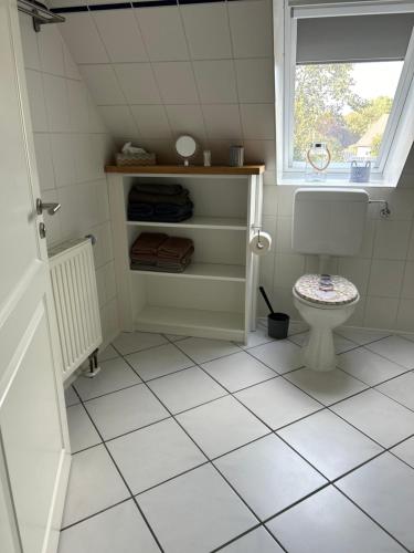 ein Bad mit einem WC und einem Fenster in der Unterkunft Lüttje Koje in Breklum