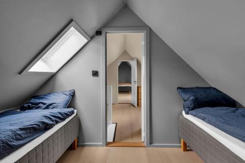 two beds with blue pillows in a attic room at Luxurious Penthouse in the Middle of City Center in Bergen