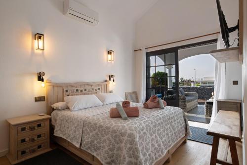 Un dormitorio con una cama con dos animales de peluche encima. en Villa Maylands, en Playa Blanca