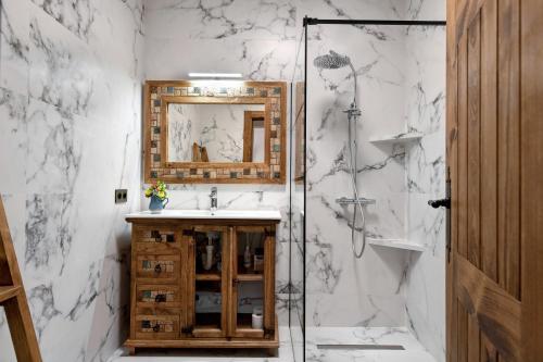 Un baño con ducha, lavabo y espejo. en Villa Maylands, en Playa Blanca