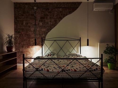 a bed in a room with a brick wall at Urban Cozy Retreat in Pristina