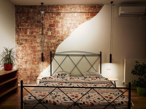 a bed in a room with a brick wall at Urban Cozy Retreat in Pristina