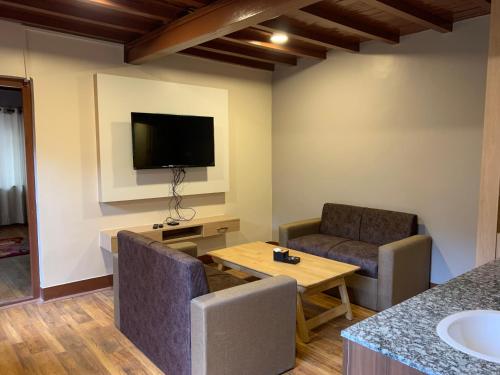 ein Wohnzimmer mit zwei Stühlen und einem Fernseher in der Unterkunft Studio Apartment in Kathmandu
