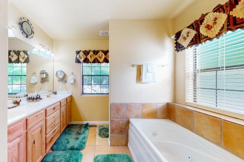 a bathroom with a tub and a sink at Osprey Cabin in Pinetop-Lakeside