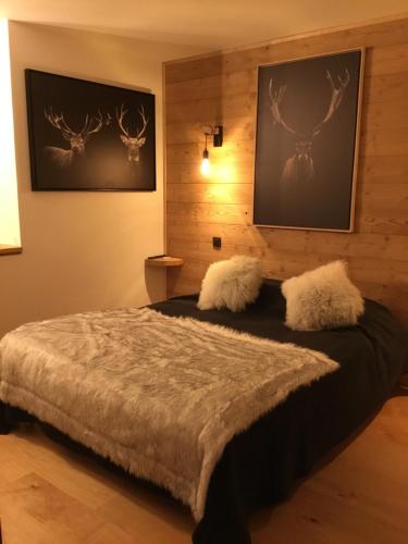 una camera da letto con un letto con due corna di cervo sul muro di Studio du cerf a Megève