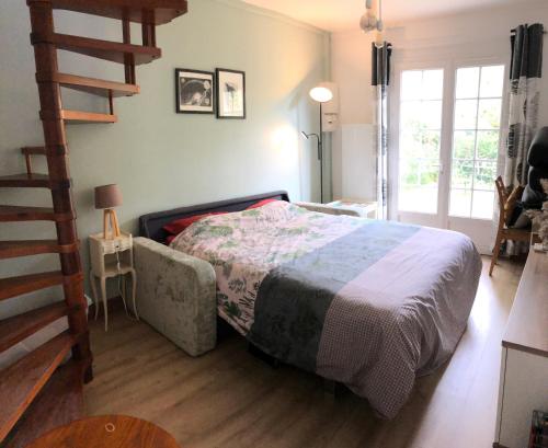 a bedroom with a bed and a wooden floor at Gîte du bout d'Auvers in Noisy-sur-École