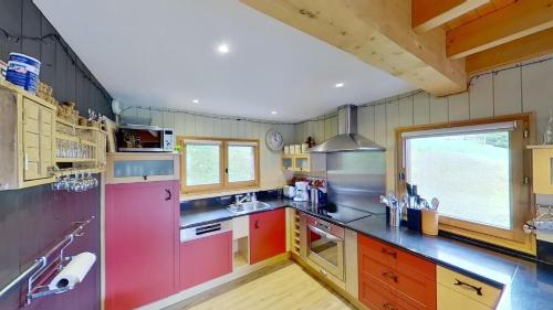 a large kitchen with red appliances and a large window at Le Chalet des Ours in Châtel