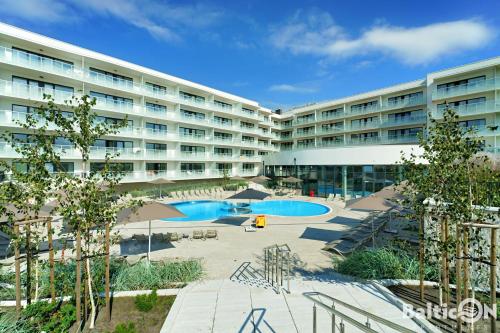 un gran edificio con 2 piscinas en un patio en Apartamenty BalticON Polanki Aqua en Kołobrzeg