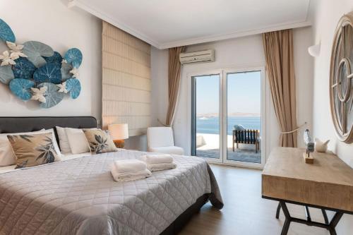 sypialnia z łóżkiem i widokiem na ocean w obiekcie Astounding Mykonos Villa 6 Bedrooms Villa El Greco Panoramic Sea Views Facing the Ancient Island of Delos Aleomandra w mieście Dexamenes