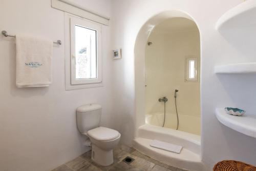 a white bathroom with a toilet and a sink at Astounding Mykonos Villa 6 Bedrooms Villa El Greco Panoramic Sea Views Facing the Ancient Island of Delos Aleomandra in Dexamenes