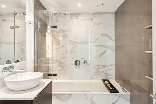 een badkamer met een witte wastafel en een douche bij Hestia Residences in Londen
