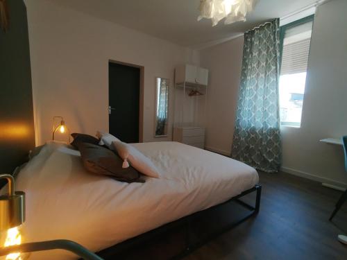 a person laying on a bed in a bedroom at Résidence Beaudelot in Saint-Saulve