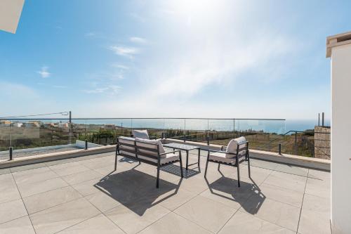 a patio with a table and two chairs on a balcony at Villa Locki with jacuzzi and private pool in Lourinhã