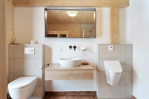 a bathroom with a sink and a toilet and a mirror at Chalet in Hohentauern - Chalet Ana in Hohentauern