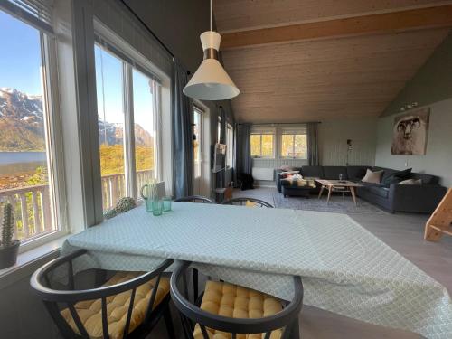 comedor con mesa, sillas y sofá en Sildpollnes Lodge, en Laupstad