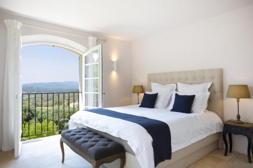 een slaapkamer met een groot bed en een groot raam bij Golfvilla Riviera in Grimaud