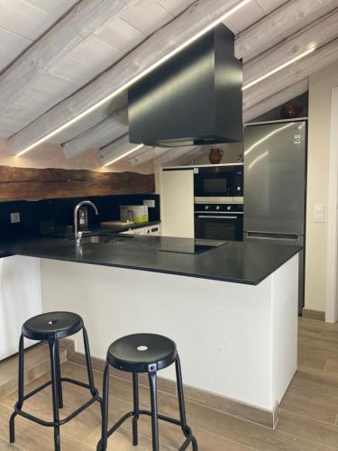 a kitchen with two stools and a counter with a sink at Casa Víctor in Albarracín