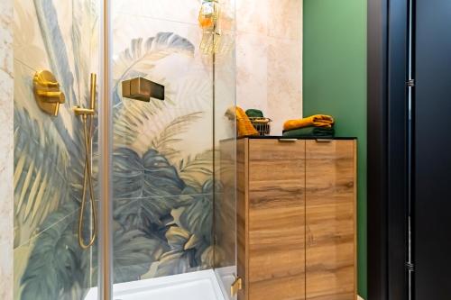 a shower with a glass door in a bathroom at Apartament Gold in Biała Podlaska