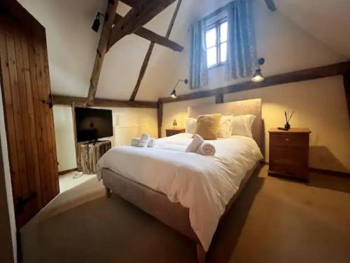 1 dormitorio con 1 cama blanca grande y TV en Pass the Keys The Granary the perfect Country Cottage all year en Ashford