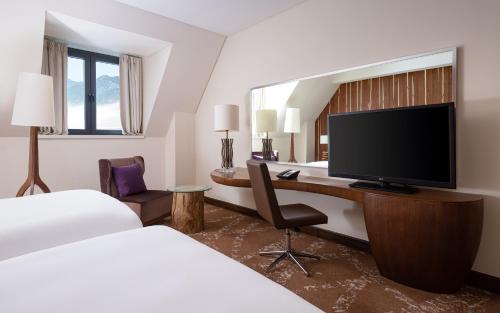 a hotel room with a desk and a tv at Park Chalet, Shahdag, Autograph Collection in Shahdag