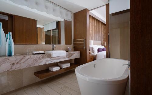 a bathroom with a white tub and a large mirror at Park Chalet, Shahdag, Autograph Collection in Shahdag