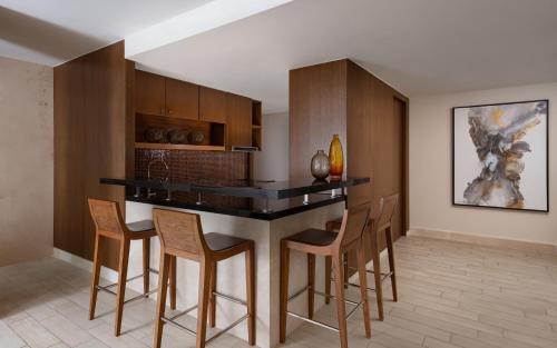 a kitchen with a bar with chairs around it at Park Chalet, Shahdag, Autograph Collection in Shahdag