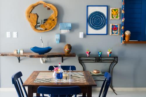uma sala de jantar com uma mesa de madeira e cadeiras azuis em Pousada Vila de Charme em Barreirinhas