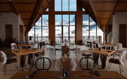 a restaurant with tables and chairs with mountains in the background at Park Chalet, Shahdag, Autograph Collection in Shahdag