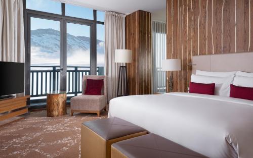 a hotel room with a bed and a large window at Park Chalet, Shahdag, Autograph Collection in Shahdag