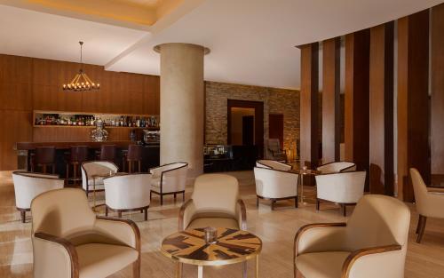 a lobby with chairs and tables and a bar at Park Chalet, Shahdag, Autograph Collection in Shahdag