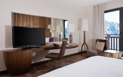 a hotel room with a bed and a desk with a television at Park Chalet, Shahdag, Autograph Collection in Shahdag