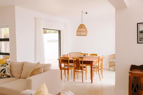 una sala de estar blanca con mesa y sillas en 7 Pepper Street by African Perfection, en Jeffreys Bay