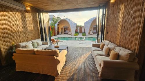 sala de estar con 2 sofás y piscina en Bamboo Estate Legian, en Legian