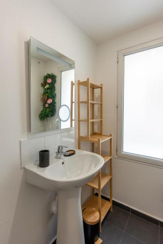 une salle de bain avec un lavabo, un miroir et une fenêtre dans l'établissement Appartement cozy - Neuilly Plaisance - 30min PARIS, à Neuilly-Plaisance