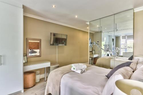 a bedroom with two beds and a mirror at Hyde Park on the Square in Cape Town