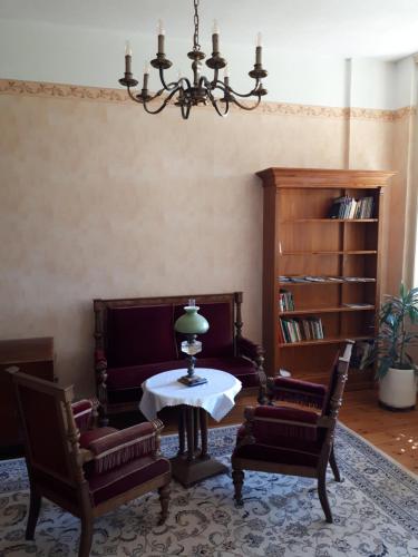 a living room with a table and two chairs and a chandelier at Gutshaus Alt-Krassow in Lalendorf